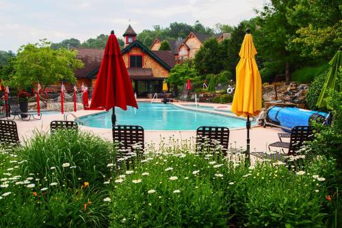 a pool with chairs and umbrellas in a yard at Spacious Condo with View Less Than 1 Mi to Mtn Creek Resort! in Vernon Township