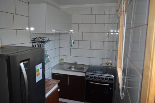 Elle comprend une petite cuisine équipée d'un évier et d'un réfrigérateur noir. dans l'établissement Sima Michi, à Puerto Natales