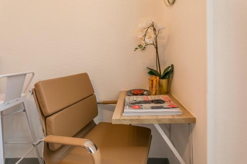 un bureau avec une chaise et une table avec un magazine dans l'établissement WS Marais - République, à Paris