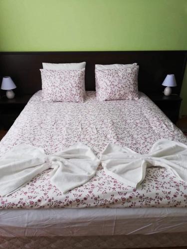 a bed with two white sheets with bows on it at Borovets Apartments, Iglika 2 in Borovets