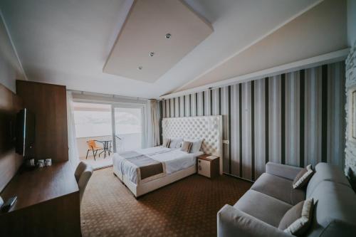 a hotel room with a bed and a couch at Rooms Nadia in Stara Baška