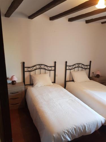 two beds sitting next to each other in a bedroom at Casa Marqueso in Figuerola de Orcau