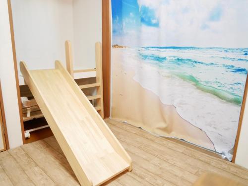 Cette chambre dispose d'une fenêtre offrant une vue sur la plage. dans l'établissement 子供部屋のある一棟貸切り 奄宿り Amayadori, à Amami