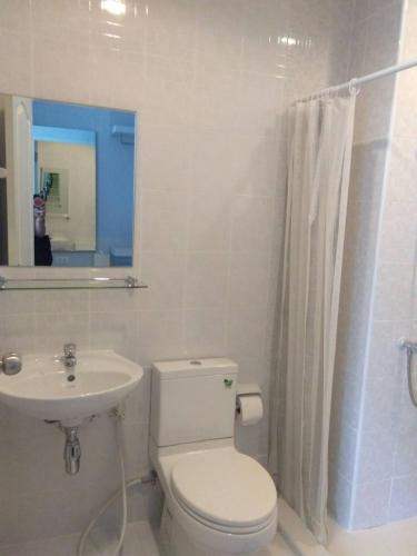 a white bathroom with a toilet and a sink at Zcape at Bangtao in Bang Tao Beach