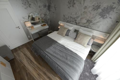 a bedroom with a large bed and a mirror at Apartman D304 in Starý Smokovec