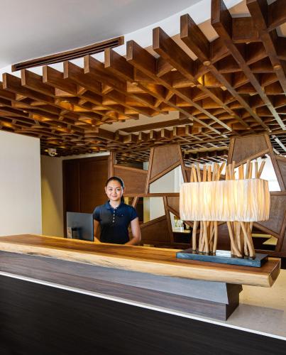 a man standing in front of a desk with a wooden ceiling at Seasalter Maldives in Hulhumale