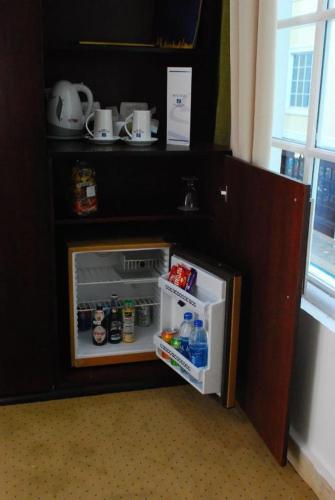 a small refrigerator with its door open in a kitchen at Spectra Inn Hotel in Cairo