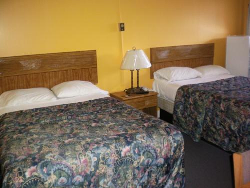 a hotel room with two beds and a lamp at The Rome Motel in Rome