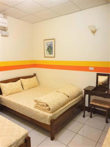 a bedroom with a bed and a desk in it at 花蓮阿羅國際青年旅舍民宿 in Hualien City