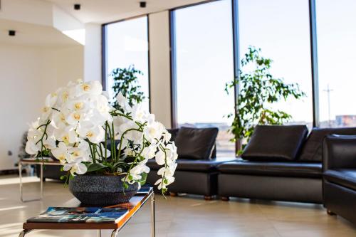 a living room with a vase of flowers on a table at SULO Atyrau Hotel in Atyraū
