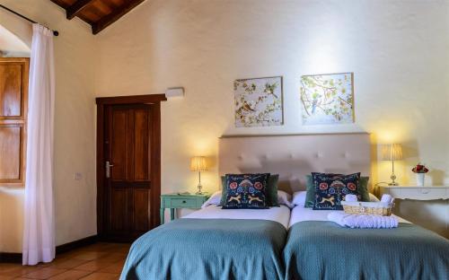 a bedroom with two beds with blue and white sheets at Casa Doña Justa in Tegueste