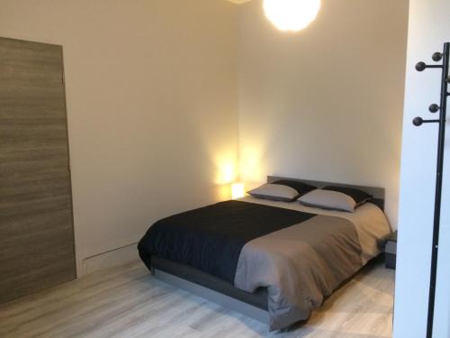 a bedroom with a bed with two pillows at STUDIO proche gare avec kitchenette et wifi - porte rouge in Thiviers