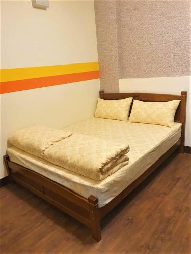 a small bed in a room with a colorful wall at 花蓮阿羅國際青年旅舍民宿 in Hualien City