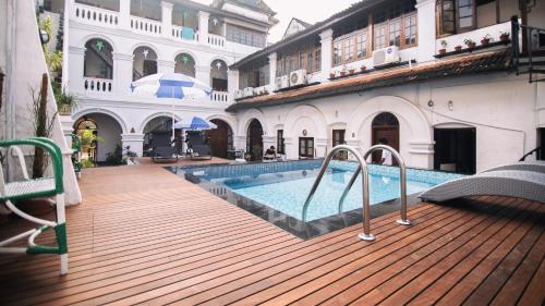 una terraza al aire libre con piscina en un edificio en Old Courtyard Hotel, en Kochi