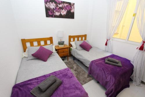 トレビエハにあるApartment in Playa Los Locos - Torrevieja Ref 4557の小さな部屋のベッド2台 紫色のシーツ付