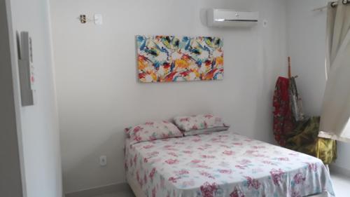 ein Schlafzimmer mit einem Bett und einem Gemälde an der Wand in der Unterkunft Casa com Piscina em Guaratiba in Prado
