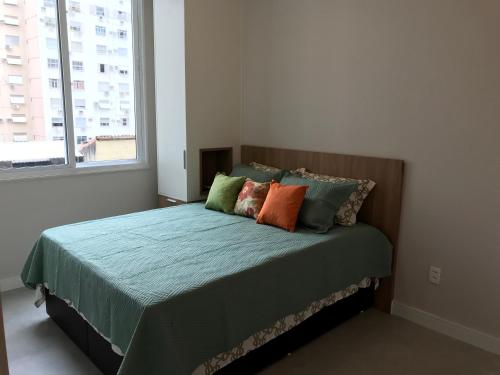 1 dormitorio con cama con almohadas y ventana en Fantástico STUDIO DIVISA COPACABANA IPANEMA REFORMADO E DECORADO en Río de Janeiro