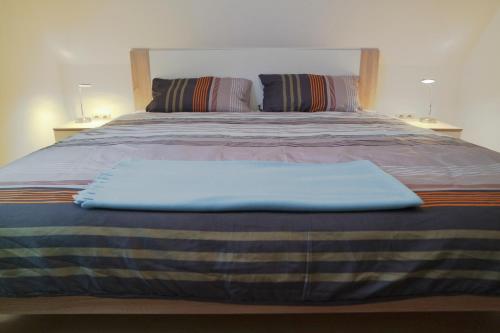 Una cama grande con una manta azul encima. en Ferienwohnung Carla, en Celle