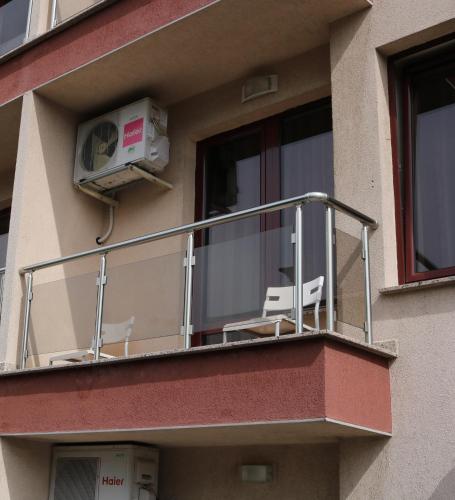 a balcony with two chairs and a air conditioner at Favorit Hotel in Sofia