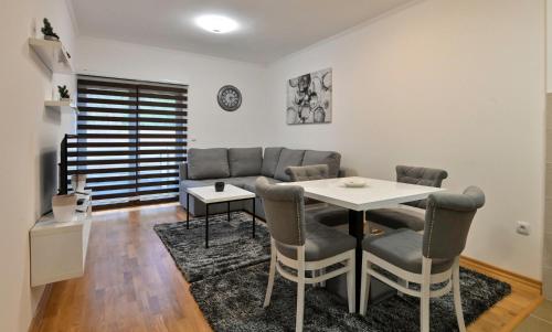 a living room with a table and a couch at Zova Deluxe Apartment in Zlatibor