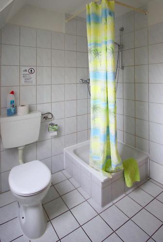 a bathroom with a toilet and a tub and a shower curtain at Ferienwohnung Carla in Celle