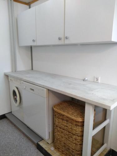 a kitchen counter with a washing machine and cabinets at Charmantes Ferienhaus in Nordfriesland in Humptrup