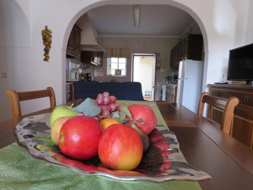 a plate of fruit on a table in a kitchen at Casa do Quintalão in Raposeira