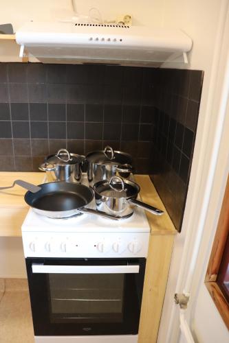 a stove with pots and pans on top of it at Motelli Online Oy in Porvoo