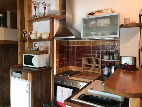 uma pequena cozinha com um micro-ondas e um fogão em T2 Jausiers em Jausiers