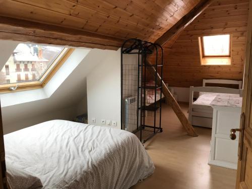 Un dormitorio con una cama y una escalera en un ático en T2 Jausiers, en Jausiers