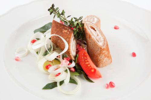 a white plate with a sandwich and vegetables on it at Podere Brizio in Montalcino