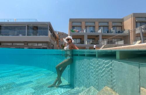 a woman standing in the water in a swimming pool at Kiani Beach Resort Family All Inclusive in Kalyves