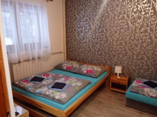 a bedroom with two beds and a wall at Gazdówka "Pod Pstrągiem" in Korbielów