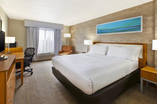 a hotel room with a large bed and a desk at Holiday Inn & Suites Bolingbrook by IHG in Bolingbrook