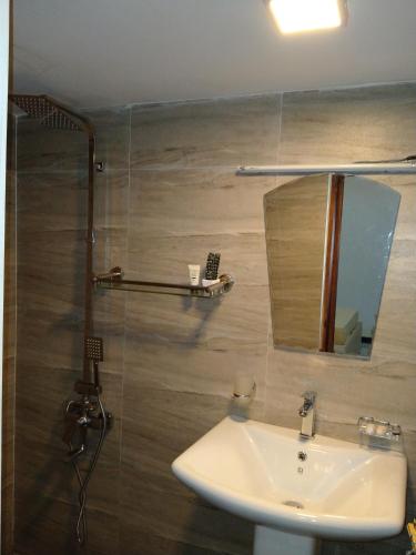 a bathroom with a sink and a shower with a mirror at Living Home in Negombo