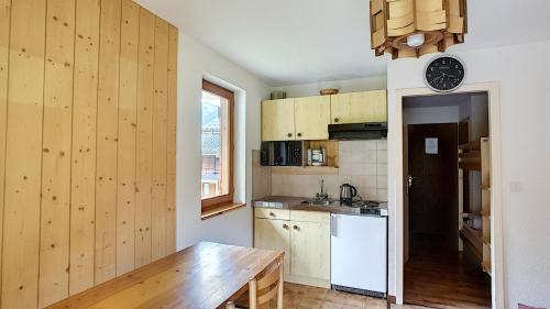 - une cuisine avec des murs en bois et une table en bois dans l'établissement APPARTEMENT ST JEAN D'AULPS - PROCHE MORZINE - PIED DES PISTES - Moussière 8, à Saint-Jean-dʼAulps