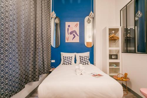 une chambre avec un lit et un mur bleu dans l'établissement WS Marais - République, à Paris