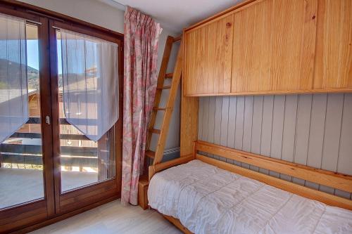 Un dormitorio pequeño con una litera y una ventana. en APPARTEMENT PROCHE MORZINE CENTRE ET REMONTEES MECANIQUES - Orée de Morzine 24A, en Montriond