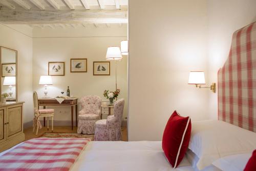 a bedroom with a bed and a desk and a table at Podere Brizio in Montalcino