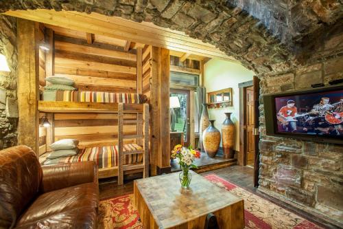 a living room with a couch and a tv at Charming Bunkhouse, Private Porch, Double Shower in Franklin