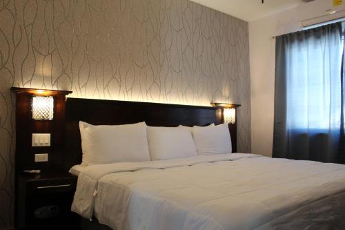 a bedroom with a large bed with white sheets at Barefoot Caye Caulker Hotel in Caye Caulker