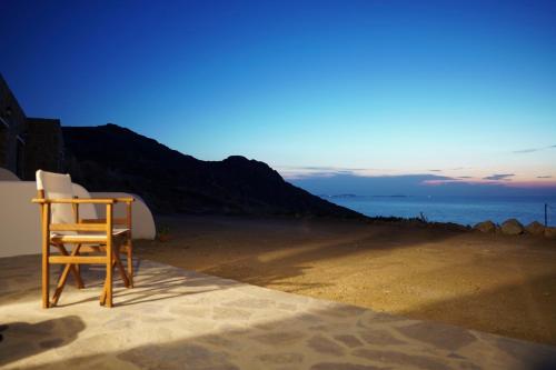 a wooden chair sitting on the side of a beach at Casa Borealis in Naxos Chora