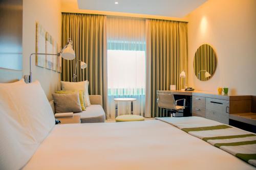 a hotel room with a large bed and a desk at Holiday Inn & Suites - Dubai Festival City by IHG in Dubai