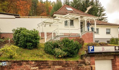 a man standing on the balcony of a house at Villa Bruderfels, Garni in Rodalben