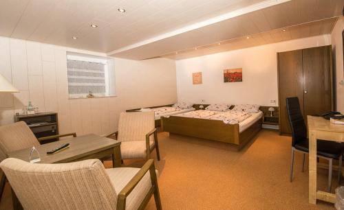a room with three beds and a table and chairs at Villa Bruderfels, Garni in Rodalben