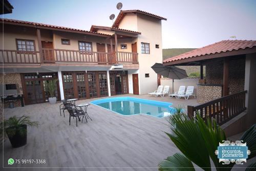 une maison avec une piscine et une terrasse dans l'établissement Pousada Encantos de Palmeiras, à Palmeiras