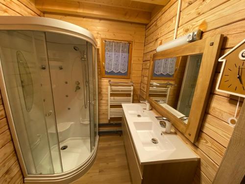a bathroom with two sinks and a shower and a mirror at le refuge des Marmottes in Saint-Laurent-du-Jura