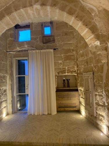 a room with a window and a stone wall at StageROOM01 - Matera in Matera
