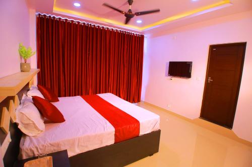 a bedroom with a bed with a red curtain at Cloudfoster Thekkady in Vandanmedu