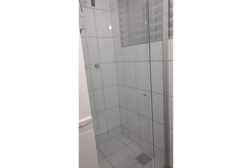 eine Dusche im Bad mit weißen Fliesen in der Unterkunft Águas da Serra Rio Quente Flats 205B in Rio Quente